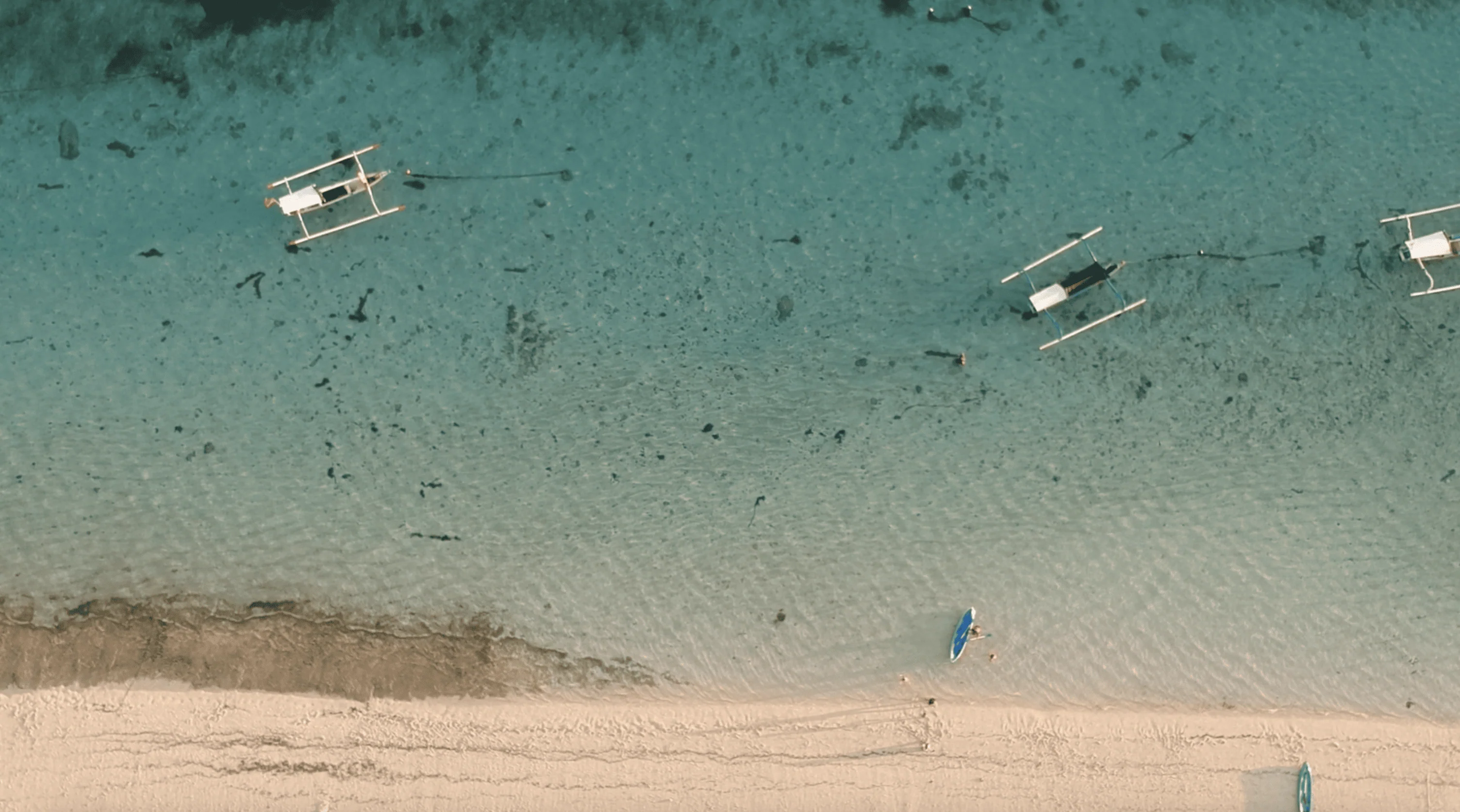 0:02 / 0:33 Pandawa Beach Bali Indonesia. Tourist boat leaning on the beach.