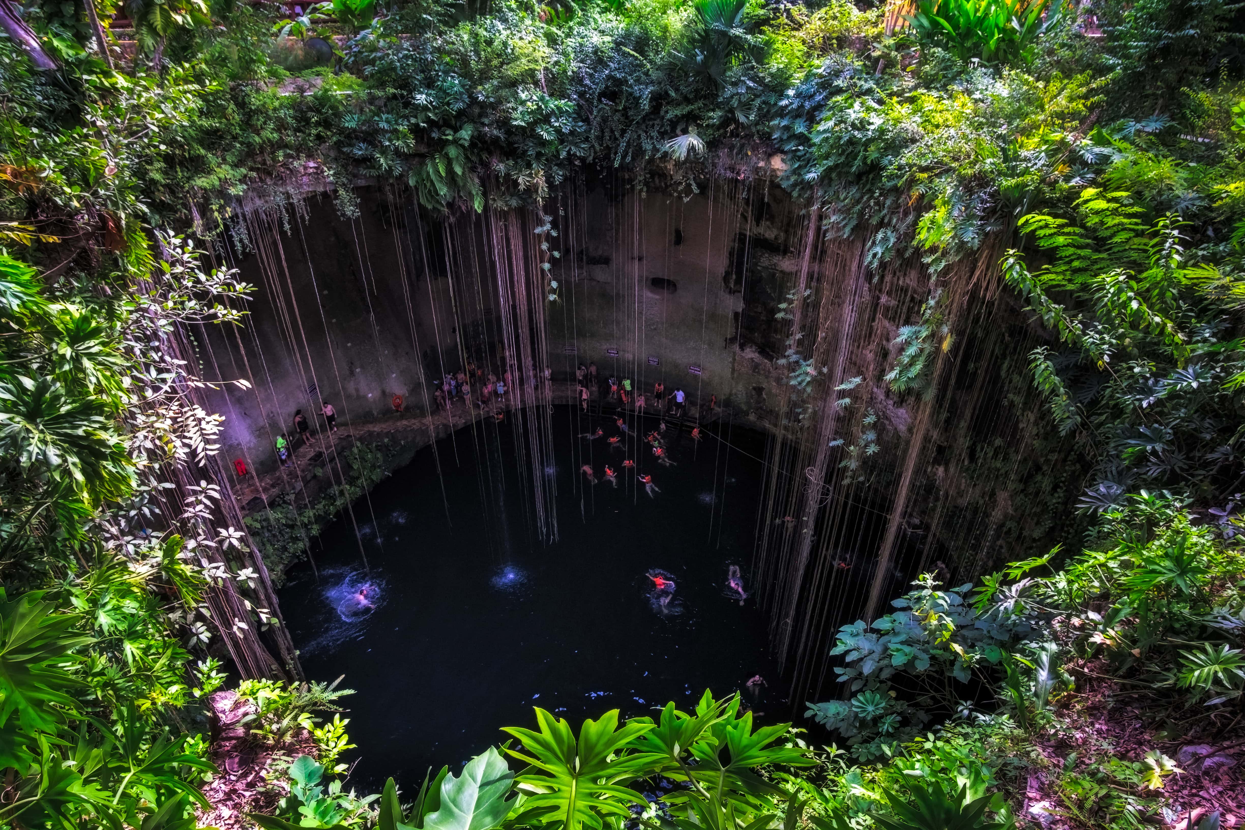 Cenote cave lake landscape view with people swimming, Chichen Itza, Mexico