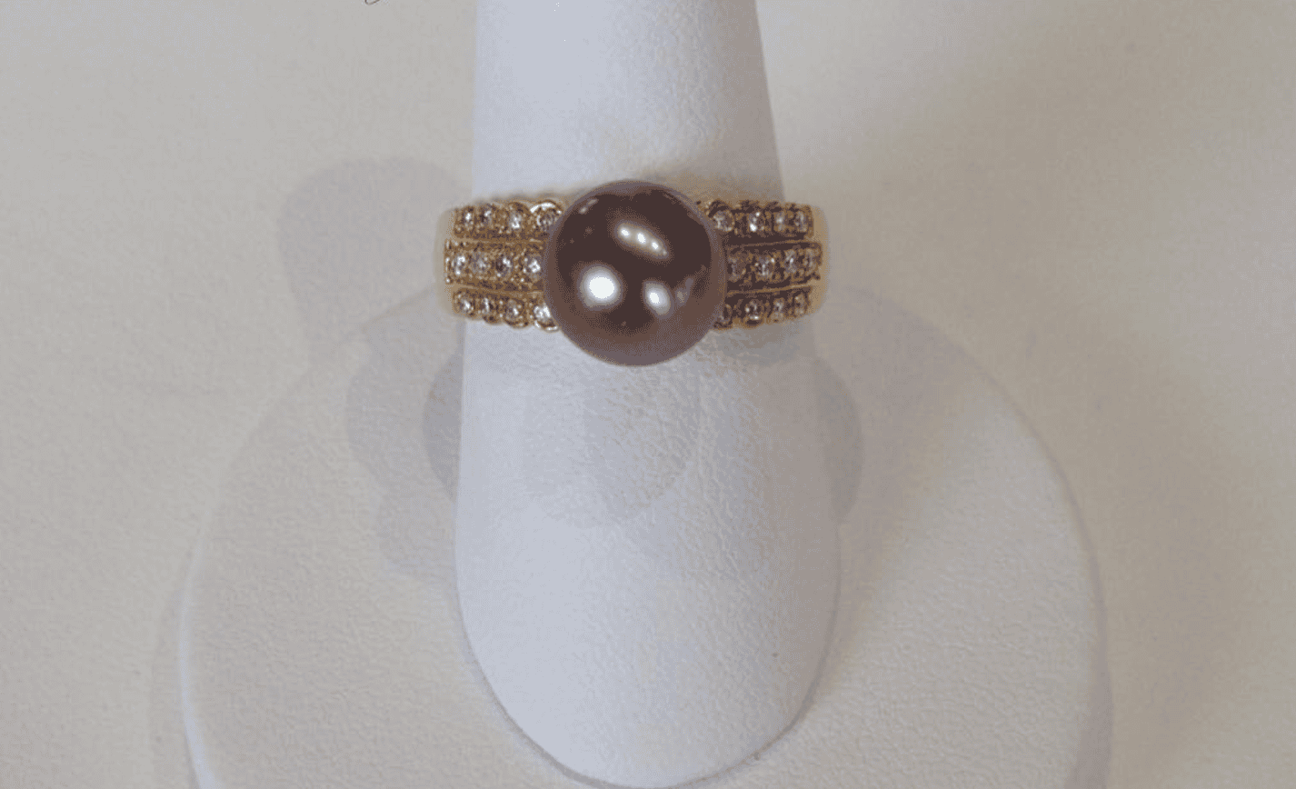A Complete Guide to Raiatea Uturoa 9 A black Tahitian pearl on a gold ring.