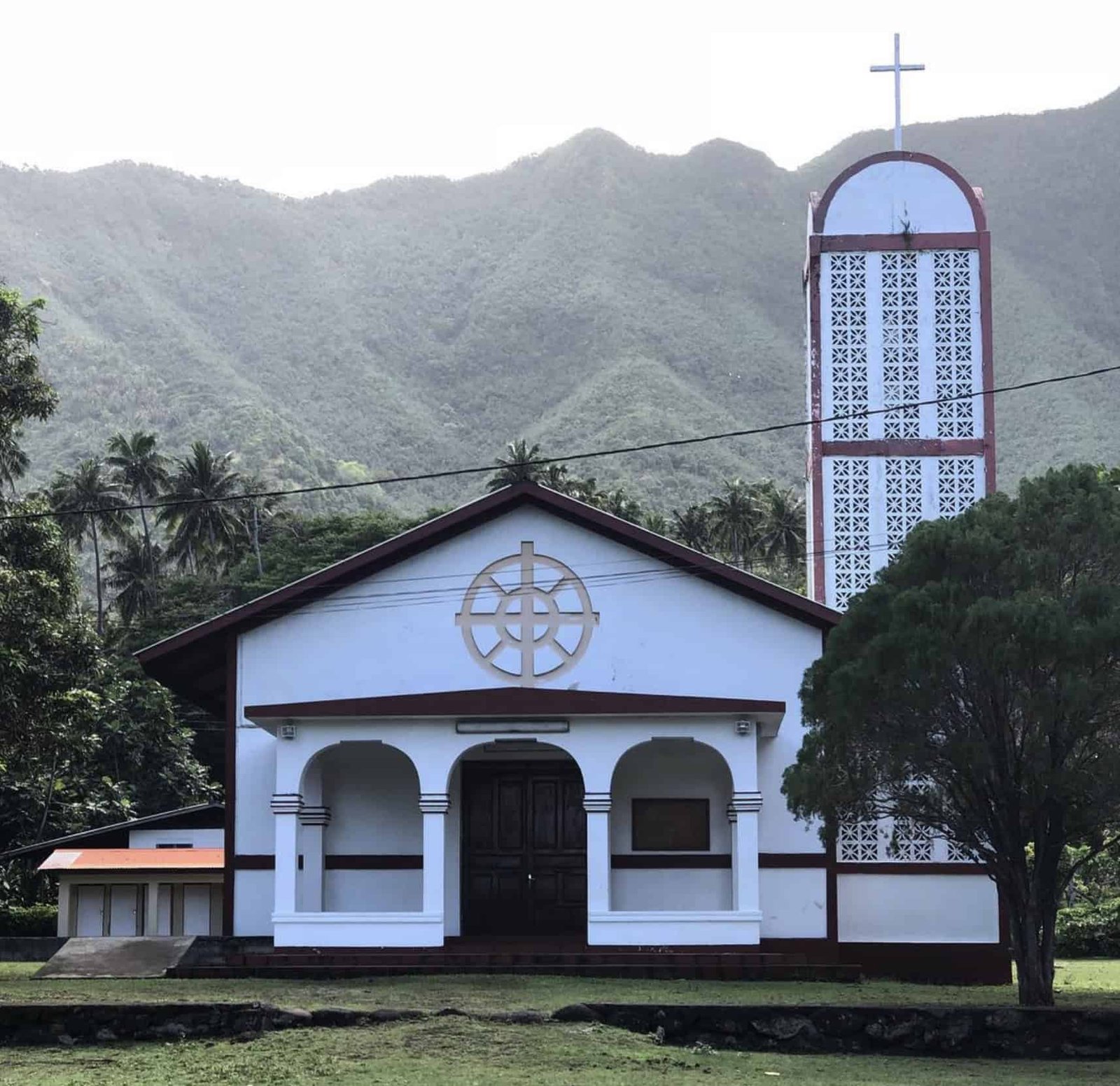 Discover Ua Huka: The Volcanic Island (with itinerary)! 9 A white church with a tall tower in front of a mountain on Ua Huka island