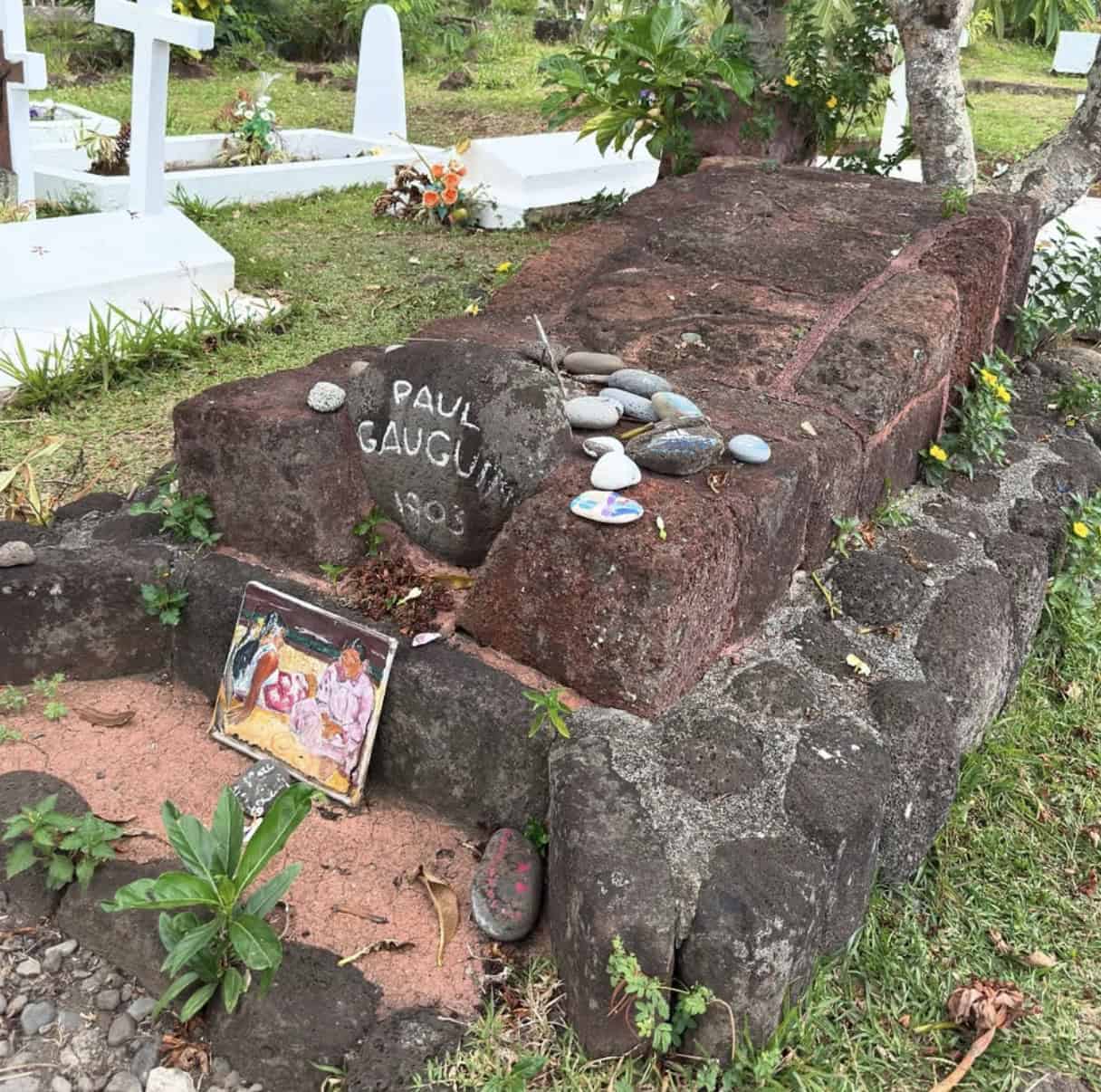 a grave stone with rocks and a picture on it from Paul Gauguin