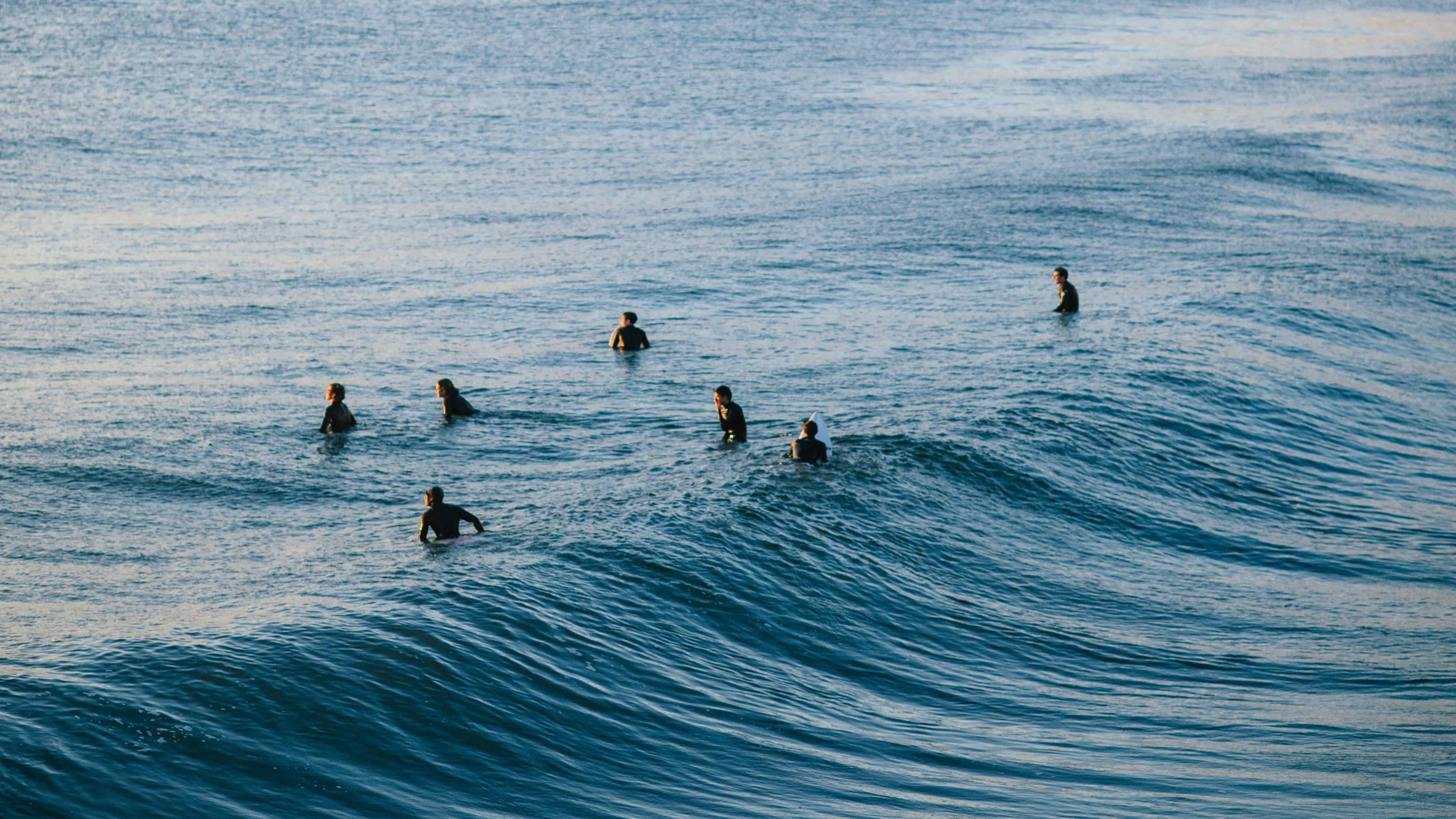 group of people in water, ready to go surfing