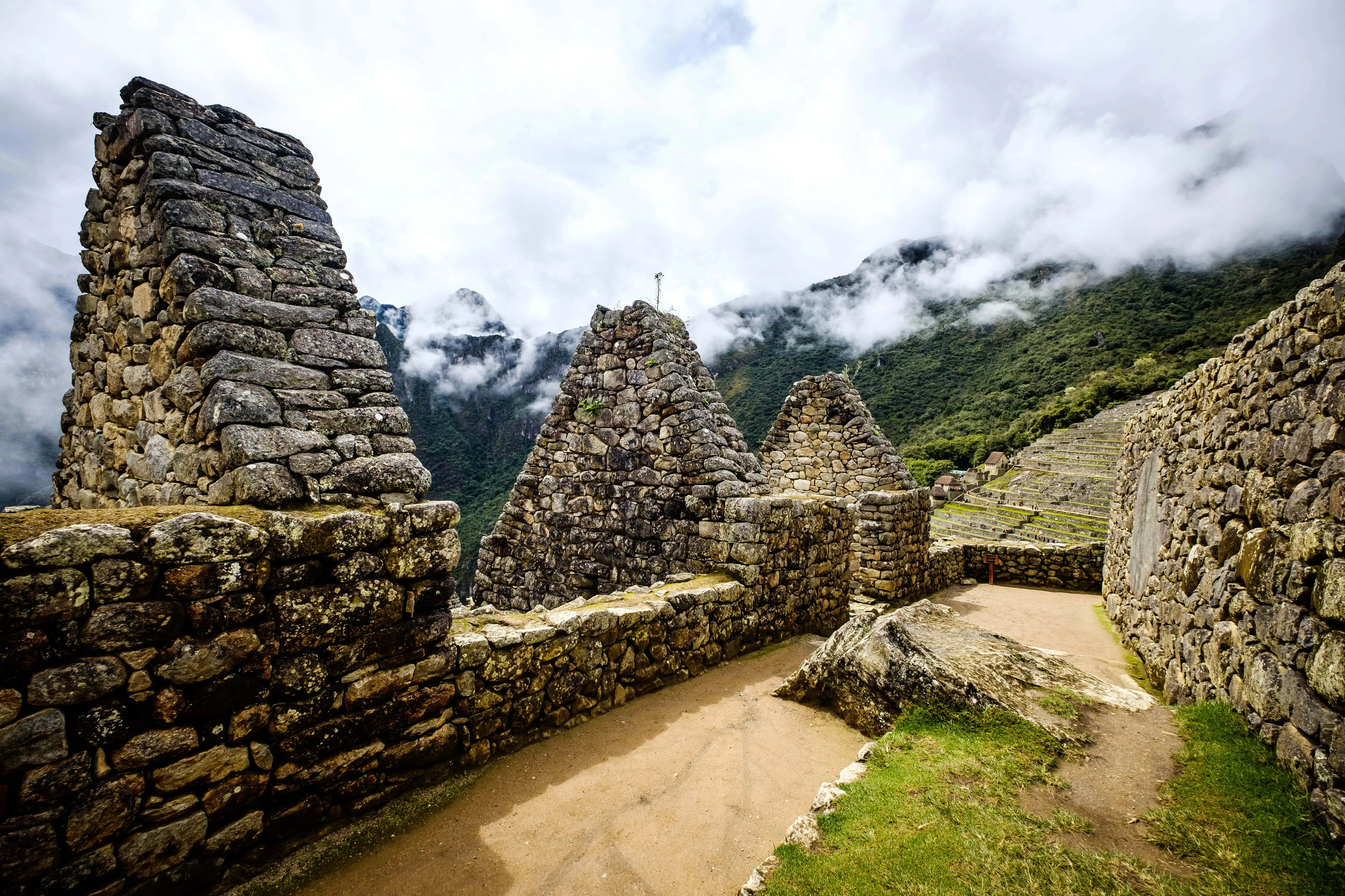 Sunshine breathtaking view of Machupicchu stone anchient walls and temple among mountains covered with clouds