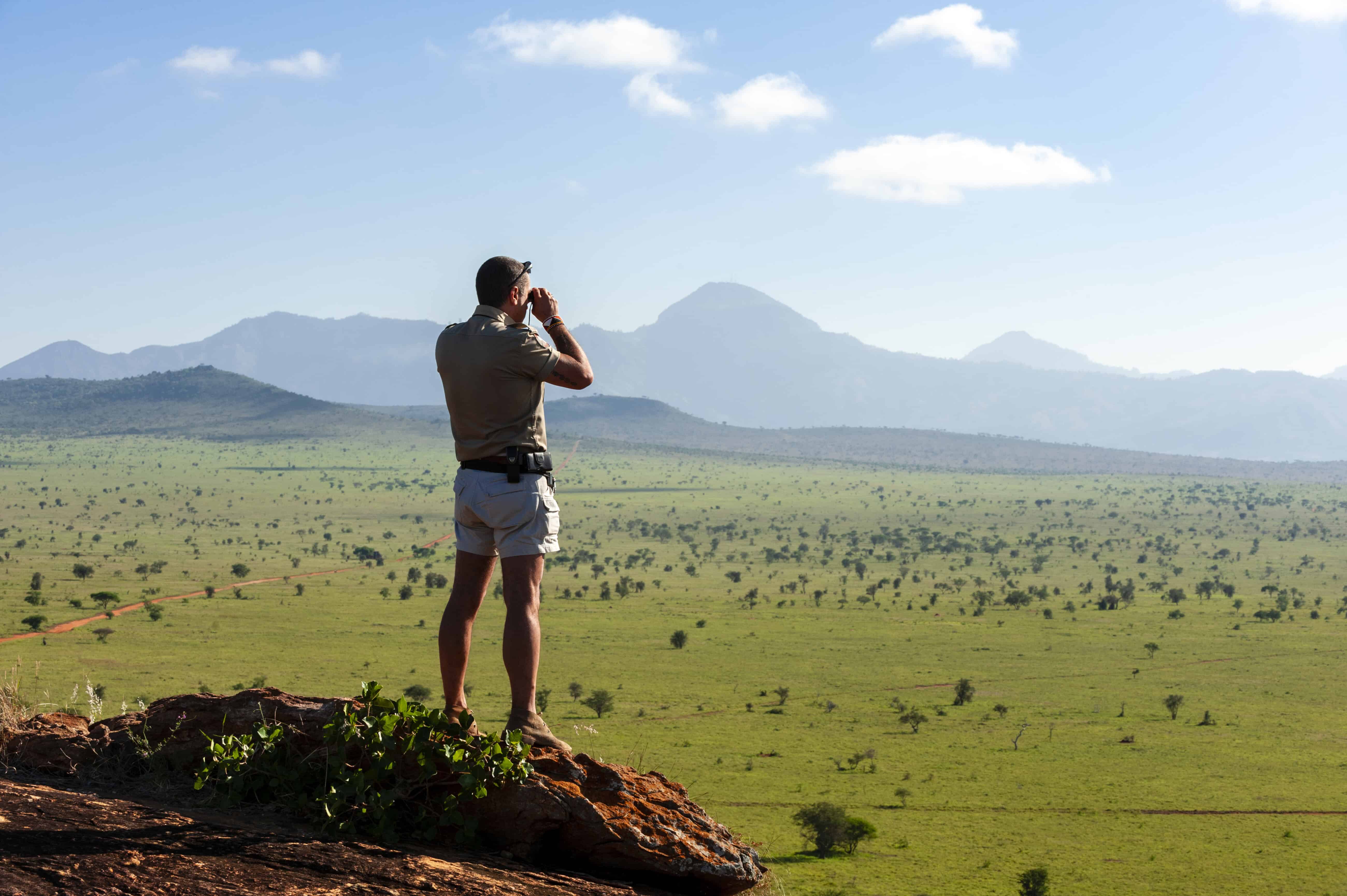 Explorer gazing across the vast savanna landscape in Kenya