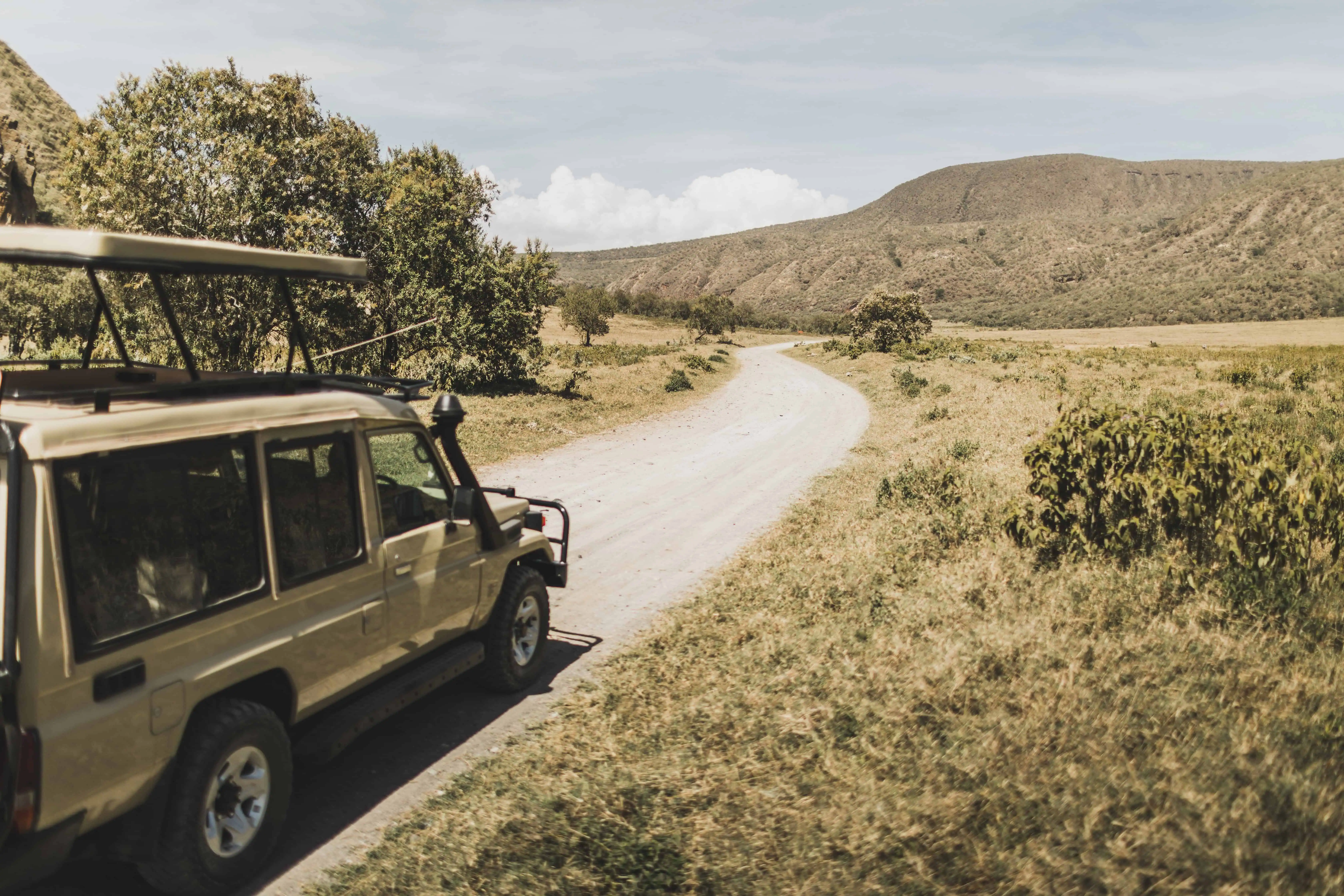 Safari in Hell's Gate national park in Kenya. Off road jeep car, savannah and mountain view. Explore wilderness of Africa.