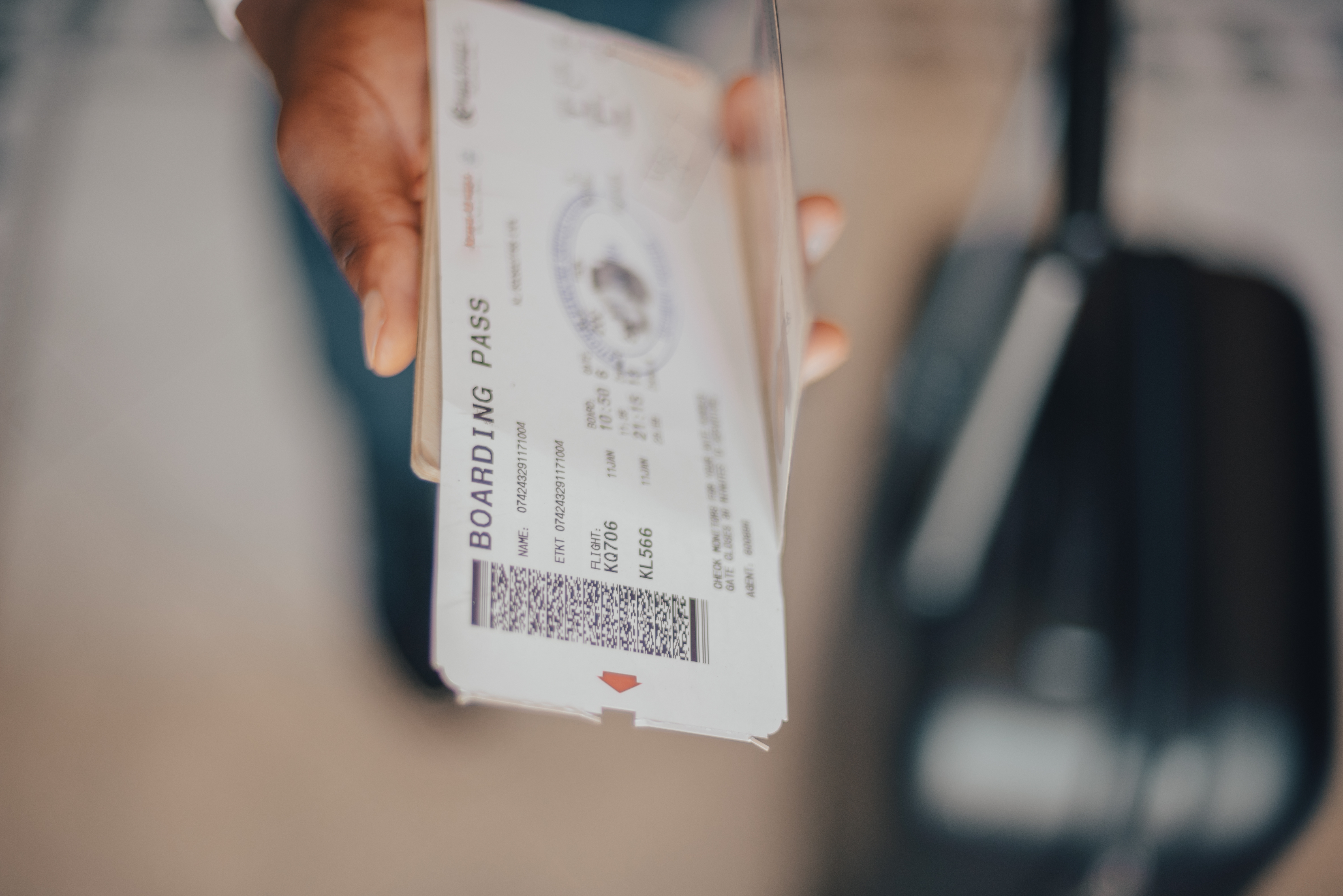 a man holding a passport and boarding pass
