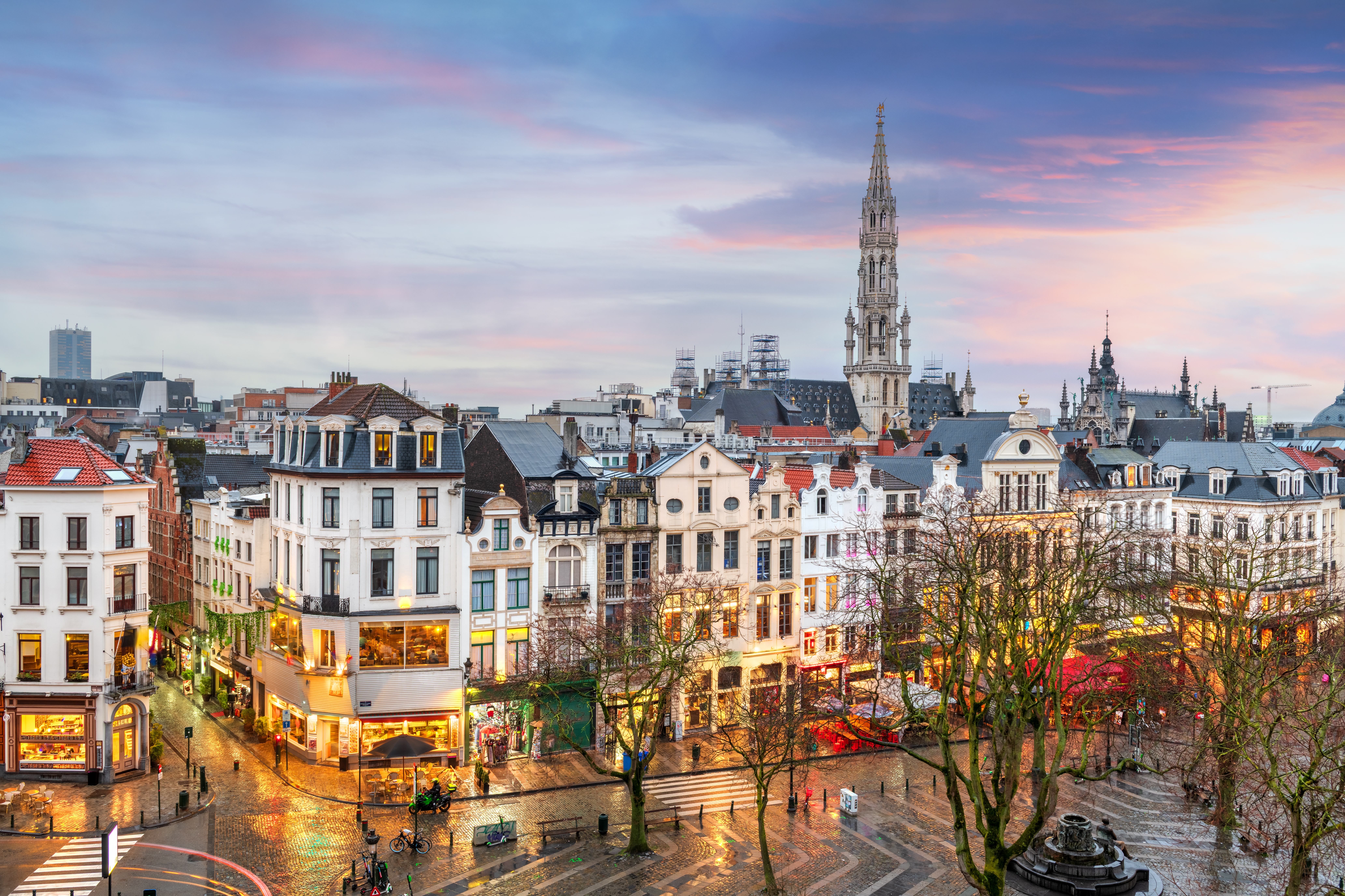 Brussels, Belgium plaza and skyline with the Town Hall tower at dusk.