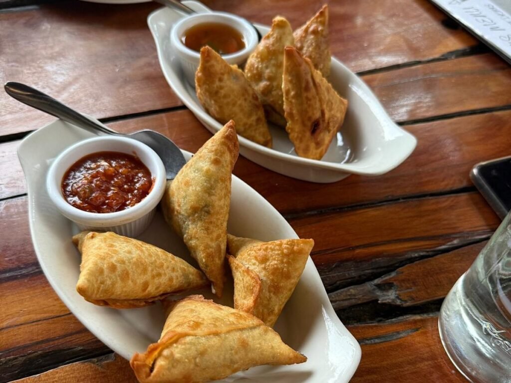 Best hotels in Naivasha Kenya: 11 picks by budget and vibe (2026 Guide) 11 Crispy vegetable samosas with dipping sauces on rustic wooden table, popular Indian appetizer, perfect for sharing, flavorful, and served with spicy chutney.