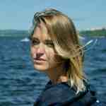 A woman with sun-kissed blonde hair enjoying a scenic ocean view, embodying freedom and adventure on the waters. Perfect for travel, coastal exploration, and oceanic photography enthusiasts.