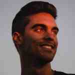 Young man smiling with sunset lighting, peaceful outdoors, clear sky background - lost between oceans theme, representing serenity, exploration, and connection with nature.