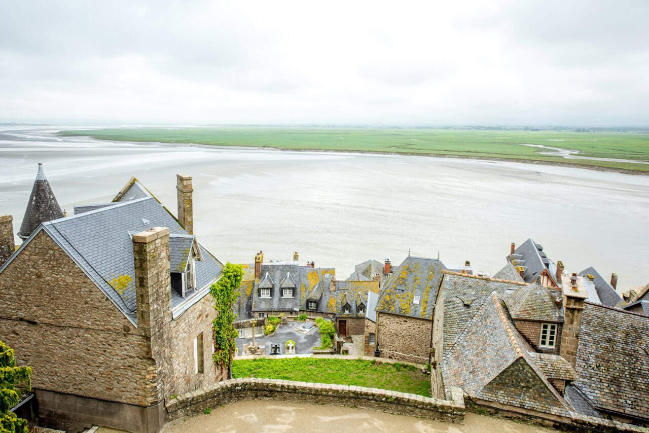 7 Charming Medieval Villages in France (2026 Expert Guide) 5 Rustic coastal village with historic stone houses overlooking peaceful marshlands and wide-open waterways, capturing the essence of serene seaside living and picturesque ocean views.