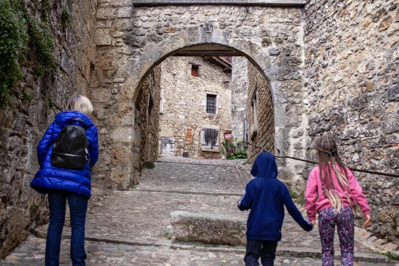 Charming cobblestone alley in a Perouges with stone archway and ancient architecture, perfect for travel and exploration.