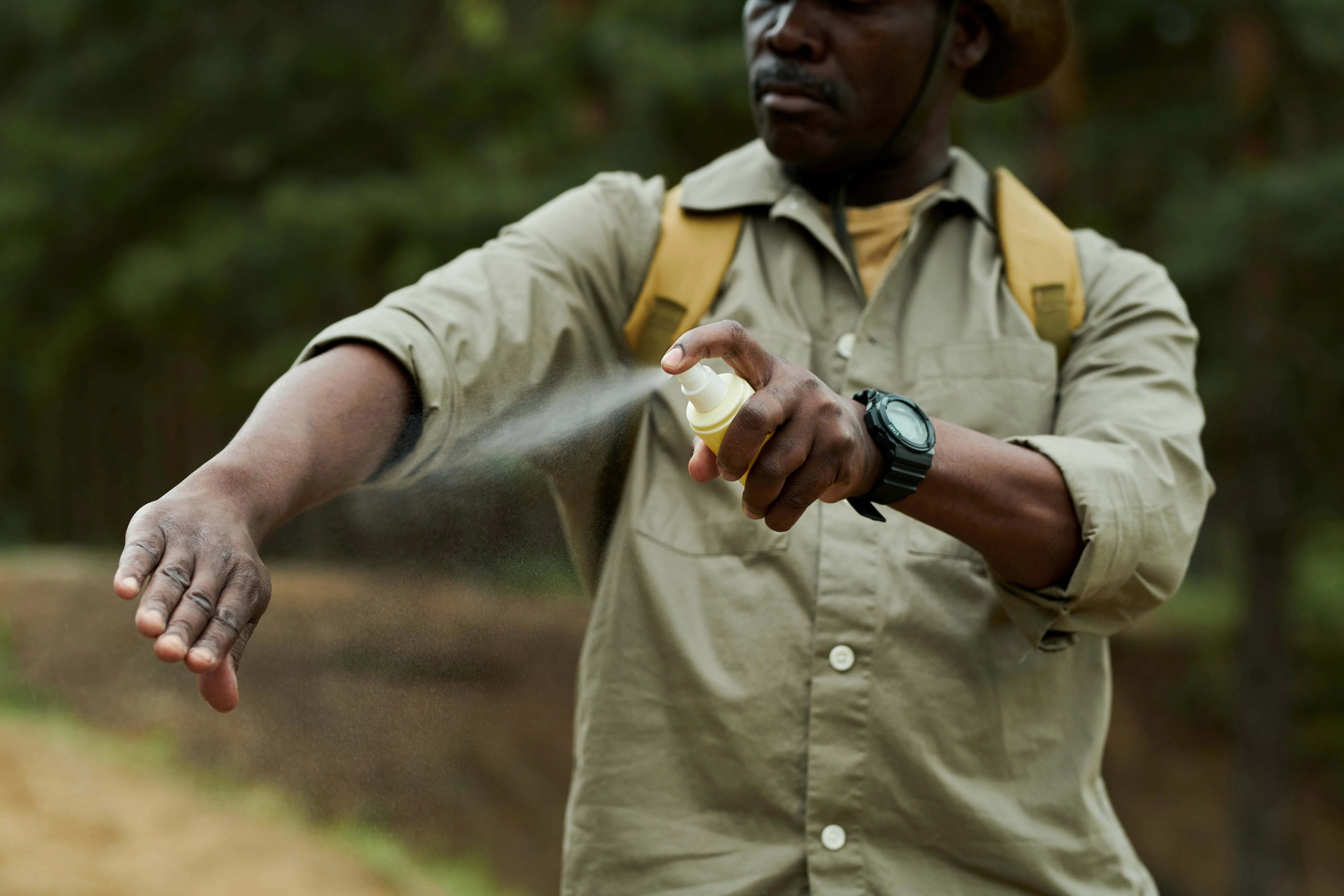 Man using mosquito spray outdoors
